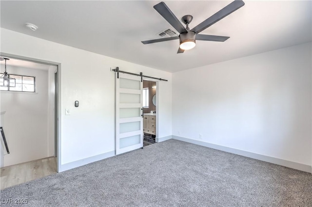 1805 Amboy Dr, Las Vegas, NV 89108 - unfurnished bedroom with a barn door, carpet flooring, and a ceiling fan