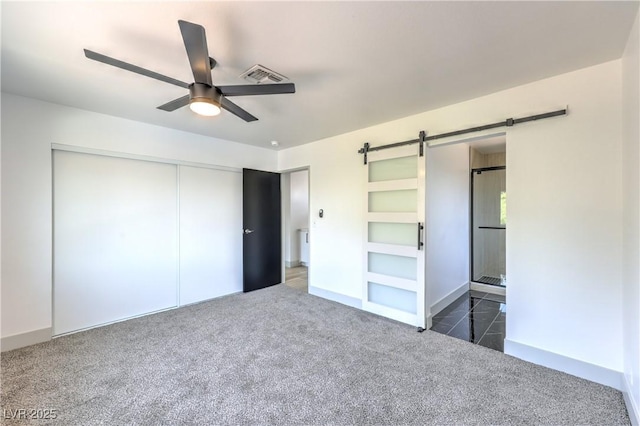 1805 Amboy Dr, Las Vegas, NV 89108 - unfurnished bedroom featuring a barn door, a closet, carpet flooring, and a ceiling fan