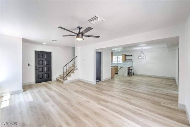 1805 Amboy Dr, Las Vegas, NV 89108 - unfurnished living room featuring stairway, light wood-style floors, and ceiling fan