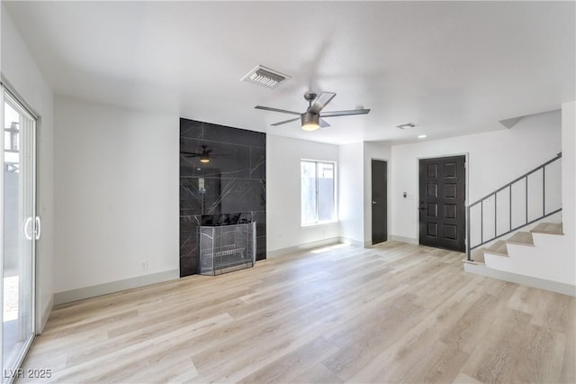 1805 Amboy Dr, Las Vegas, NV 89108 - unfurnished living room featuring wood finished floors, stairs, a ceiling fan, and a premium fireplace