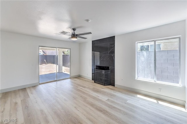 1805 Amboy Dr, Las Vegas, NV 89108 - unfurnished living room with a ceiling fan, wood finished floors, plenty of natural light, and a premium fireplace