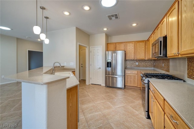 2221 River Grove Dr, Henderson, NV 89044 - kitchen featuring stainless steel appliances, tasteful backsplash, a peninsula, hanging light fixtures, and light countertops