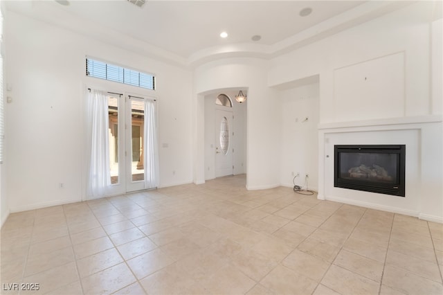 9025 Loggers Mill Ave, Las Vegas, NV 89143 - unfurnished living room featuring light tile patterned flooring, a glass covered fireplace, a towering ceiling, baseboards, and recessed lighting