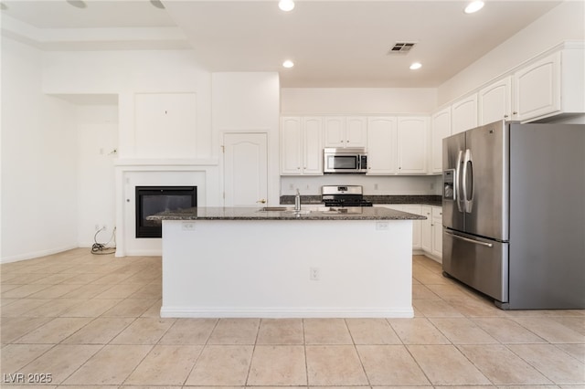 9025 Loggers Mill Ave, Las Vegas, NV 89143 - kitchen featuring appliances with stainless steel finishes, dark stone countertops, white cabinetry, light tile patterned floors, and recessed lighting