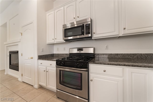 9025 Loggers Mill Ave, Las Vegas, NV 89143 - kitchen featuring stainless steel appliances, white cabinets, light tile patterned floors, and dark stone counters