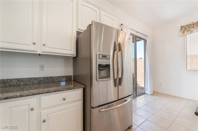 9025 Loggers Mill Ave, Las Vegas, NV 89143 - kitchen with stainless steel fridge with ice dispenser, white cabinets, light tile patterned floors, and dark stone counters