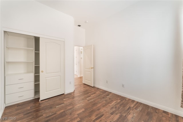 9025 Loggers Mill Ave, Las Vegas, NV 89143 - unfurnished bedroom featuring dark wood-type flooring, baseboards, a closet, and a towering ceiling