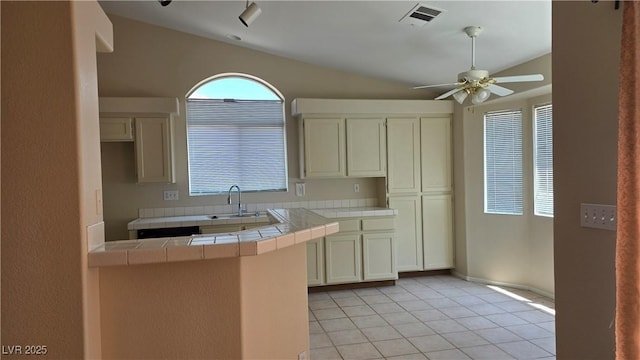 6113 Desert Haven Rd, Las Vegas, NV 89130 - kitchen with tile counters, ceiling fan, vaulted ceiling, a sink, and light tile patterned flooring