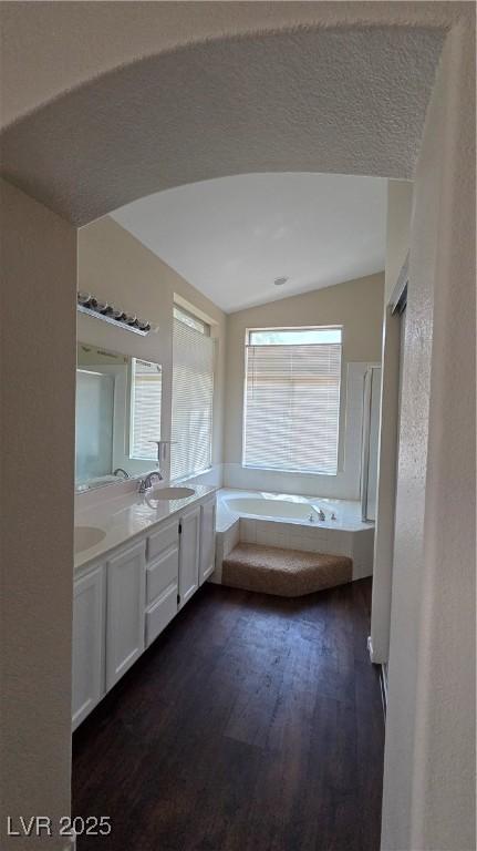 6113 Desert Haven Rd, Las Vegas, NV 89130 - bathroom with wood finished floors, vaulted ceiling, a garden tub, and double vanity