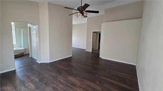 6113 Desert Haven Rd, Las Vegas, NV 89130 - spare room with a high ceiling, a ceiling fan, dark wood finished floors, arched walkways, and baseboards