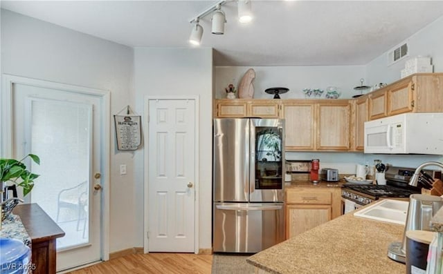 9975 Peace Way Unit 1069, Las Vegas, NV 89147 - kitchen with appliances with stainless steel finishes, light brown cabinetry, and light wood finished floors