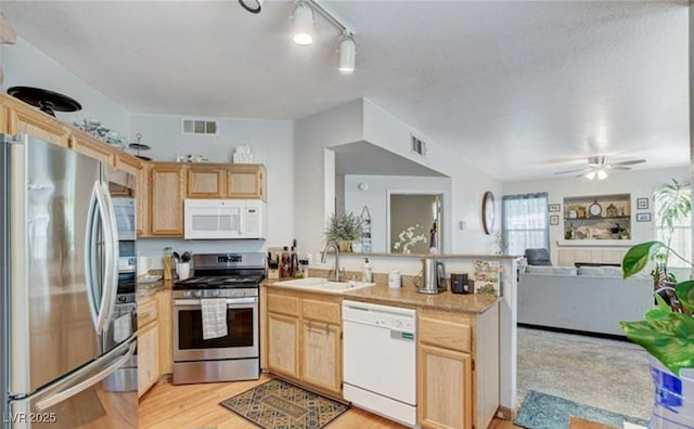 9975 Peace Way Unit 1069, Las Vegas, NV 89147 - kitchen featuring stainless steel appliances, light brown cabinetry, a peninsula, a sink, and open floor plan