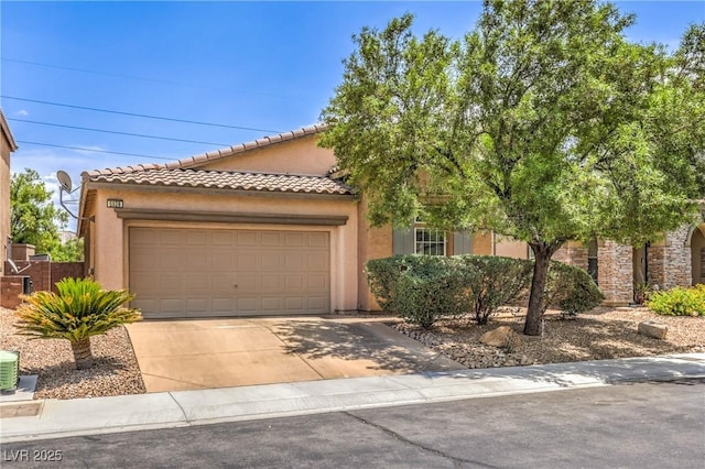 5528 Stone Lagoon St, North Las Vegas, NV 89031 - view of front of home featuring an attached garage, stucco siding, concrete driveway, and a tile roof