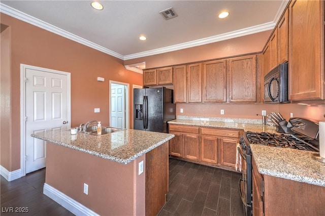 5528 Stone Lagoon St, North Las Vegas, NV 89031 - kitchen with black appliances, brown cabinetry, dark wood finished floors, ornamental molding, and light stone countertops