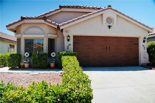 9355 W Viking Rd, Las Vegas, NV 89147 - mediterranean / spanish house featuring an attached garage, concrete driveway, stucco siding, and a tile roof