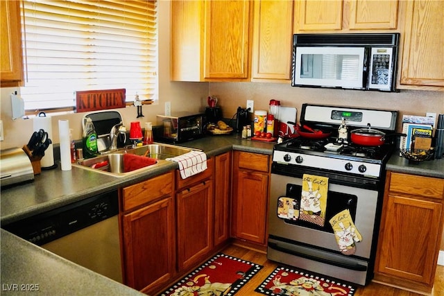 9355 W Viking Rd, Las Vegas, NV 89147 - kitchen featuring appliances with stainless steel finishes, wood finished floors, dark countertops, and a sink