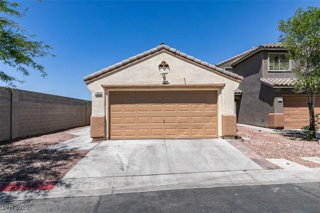 1905 Eskam St, Las Vegas, NV 89156 - view of front of property with a tiled roof, stucco siding, concrete driveway, and an attached garage