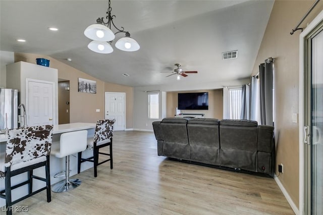 1905 Eskam St, Las Vegas, NV 89156 - living area featuring vaulted ceiling, a ceiling fan, healthy amount of natural light, light wood-type flooring, and baseboards