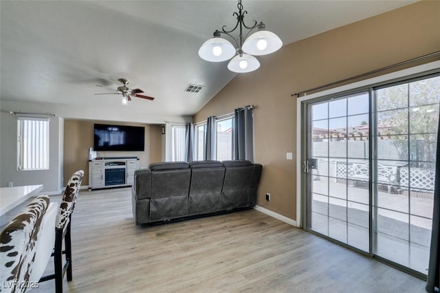 1905 Eskam St, Las Vegas, NV 89156 - living room featuring lofted ceiling, healthy amount of natural light, light wood-type flooring, a chandelier, and a ceiling fan