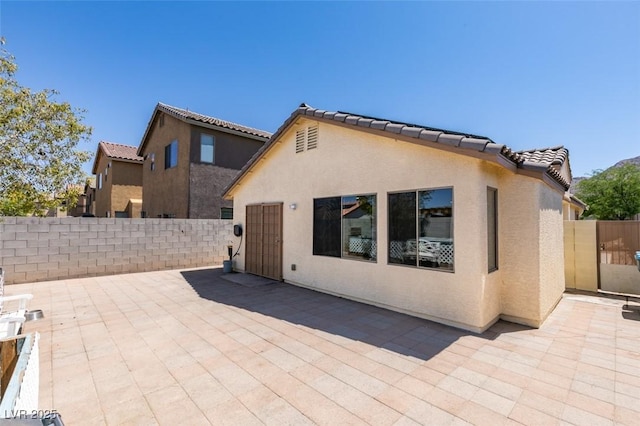 1905 Eskam St, Las Vegas, NV 89156 - rear view of house featuring a patio area, stucco siding, and a tiled roof