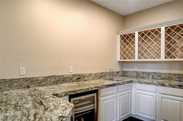 10671 Capesthorne Way, Las Vegas, NV 89135 - kitchen featuring wine cooler, a sink, and white cabinets