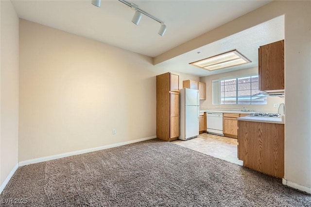 830 Carnegie St Unit 824, Henderson, NV 89052 - kitchen featuring white appliances, light colored carpet, rail lighting, light countertops, and baseboards