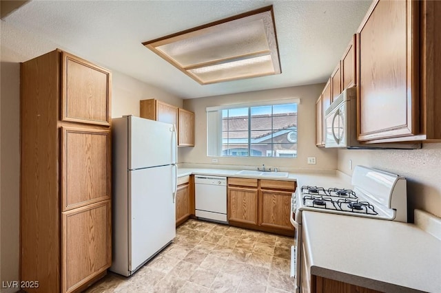 830 Carnegie St Unit 824, Henderson, NV 89052 - kitchen featuring white appliances, a sink, light countertops, and brown cabinets