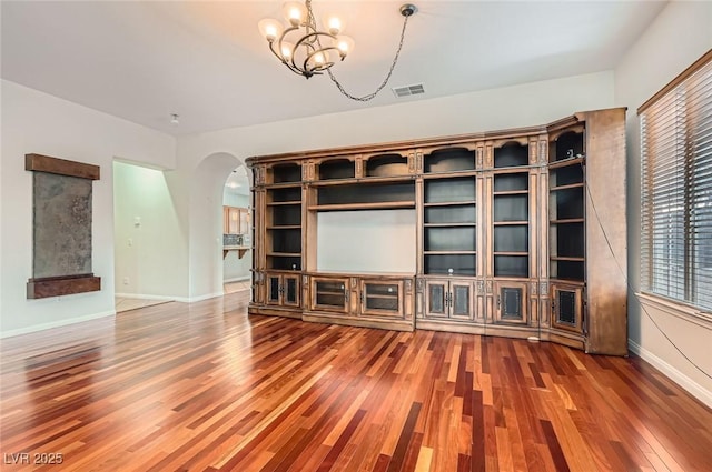 313 Glenridding St, Las Vegas, NV 89183 - unfurnished living room with arched walkways, wood finished floors, and a chandelier