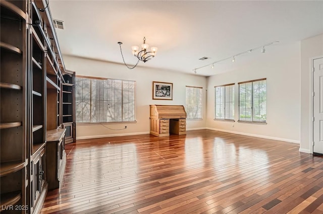 313 Glenridding St, Las Vegas, NV 89183 - unfurnished living room featuring a chandelier, track lighting, and hardwood / wood-style floors