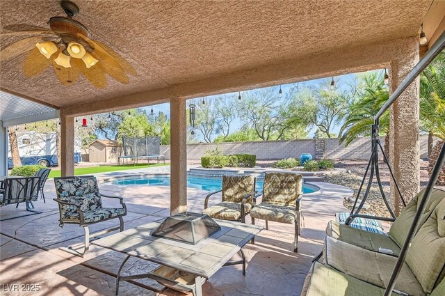 313 Glenridding St, Las Vegas, NV 89183 - fenced backyard with a trampoline, a patio, and an outdoor living space