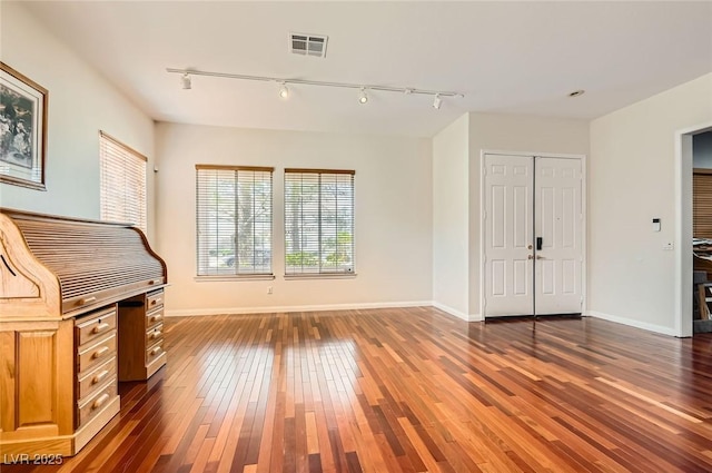 313 Glenridding St, Las Vegas, NV 89183 - unfurnished living room with rail lighting and hardwood / wood-style flooring