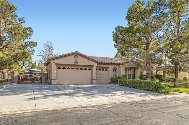 313 Glenridding St, Las Vegas, NV 89183 - mediterranean / spanish-style house featuring stucco siding, an attached garage, a gate, concrete driveway, and a tiled roof