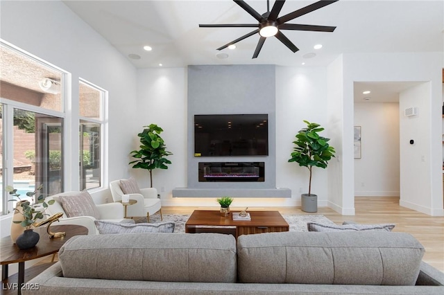 81 Alerion St, Las Vegas, NV 89138 - living area with wood finished floors, a ceiling fan, a glass covered fireplace, baseboards, and recessed lighting