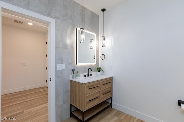 81 Alerion St, Las Vegas, NV 89138 - bathroom featuring vanity, wood finished floors, baseboards, and tile walls