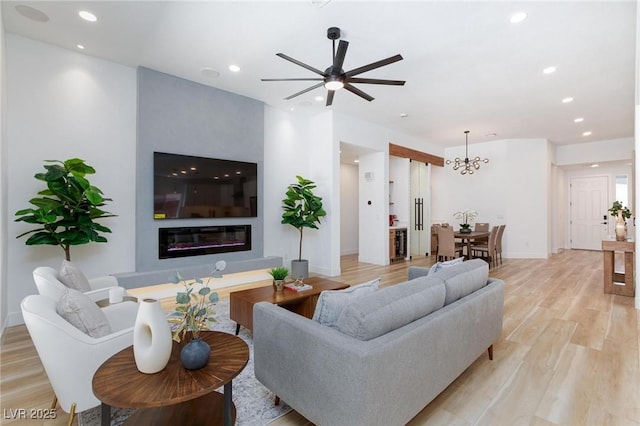 81 Alerion St, Las Vegas, NV 89138 - living room with recessed lighting, light wood finished floors, ceiling fan, a chandelier, and a glass covered fireplace