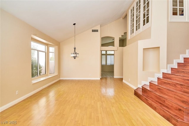 9413 Cedar Heights Ave, Las Vegas, NV 89134 - unfurnished dining area with light wood-type flooring, plenty of natural light, baseboards, a chandelier, and high vaulted ceiling