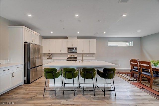 2651 Deep Canyon St, Henderson, NV 89044 - kitchen featuring stainless steel appliances, recessed lighting, light countertops, an island with sink, and a kitchen breakfast bar