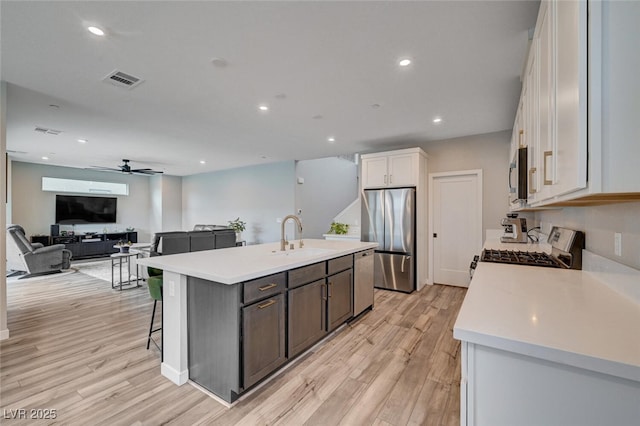 2651 Deep Canyon St, Henderson, NV 89044 - kitchen featuring appliances with stainless steel finishes, light countertops, a center island with sink, light wood-type flooring, and recessed lighting