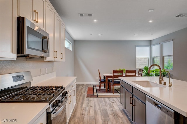 2651 Deep Canyon St, Henderson, NV 89044 - kitchen featuring appliances with stainless steel finishes, light wood-type flooring, light countertops, recessed lighting, and white cabinets