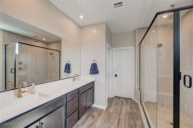 2651 Deep Canyon St, Henderson, NV 89044 - full bathroom with wood finished floors, double vanity, a shower stall, and recessed lighting