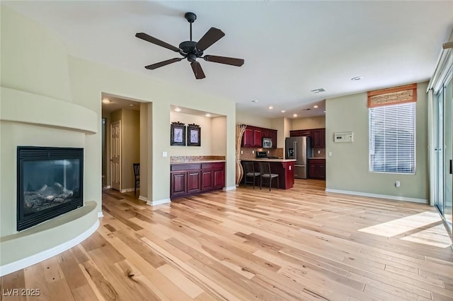 62 Myrtle Springs Ct, Las Vegas, NV 89148 - unfurnished living room featuring light wood-style flooring, a glass covered fireplace, a ceiling fan, baseboards, and recessed lighting