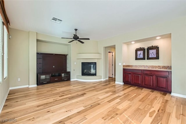 62 Myrtle Springs Ct, Las Vegas, NV 89148 - unfurnished living room featuring light wood finished floors, healthy amount of natural light, a ceiling fan, and baseboards