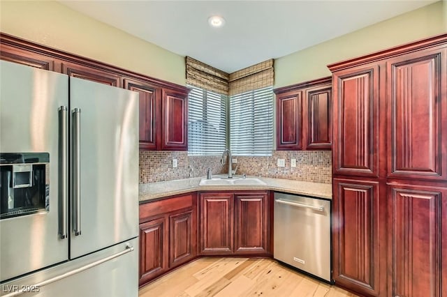 62 Myrtle Springs Ct, Las Vegas, NV 89148 - kitchen featuring stainless steel appliances, reddish brown cabinets, a sink, light wood-style flooring, and recessed lighting