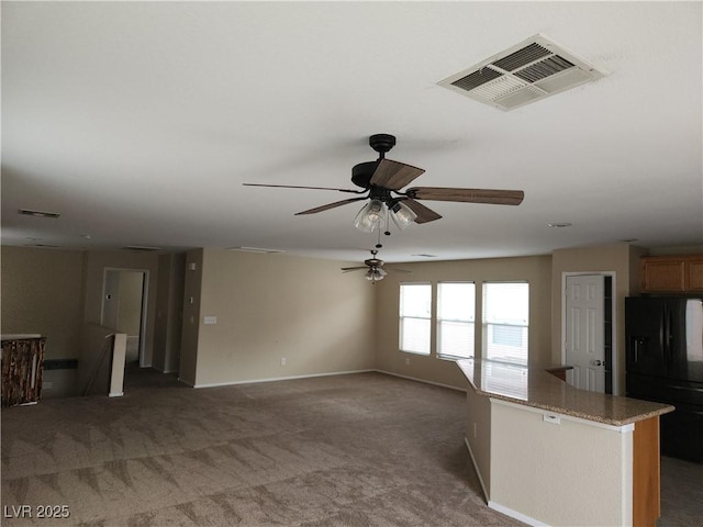 5052 Whistling Acres Ave, Las Vegas, NV 89131 - kitchen featuring black fridge, carpet flooring, a ceiling fan, and baseboards