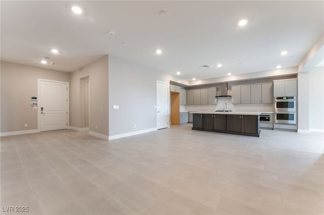 128 Los Cabos Dr Unit 301, Las Vegas, NV 89144 - kitchen featuring stainless steel double oven, wall chimney range hood, light countertops, recessed lighting, and open floor plan