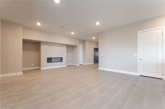 128 Los Cabos Dr Unit 301, Las Vegas, NV 89144 - unfurnished living room featuring a glass covered fireplace, recessed lighting, and baseboards