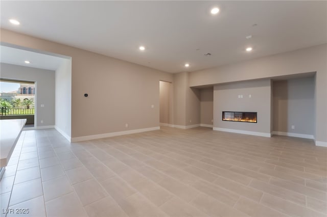128 Los Cabos Dr Unit 301, Las Vegas, NV 89144 - unfurnished living room with recessed lighting, a glass covered fireplace, and baseboards