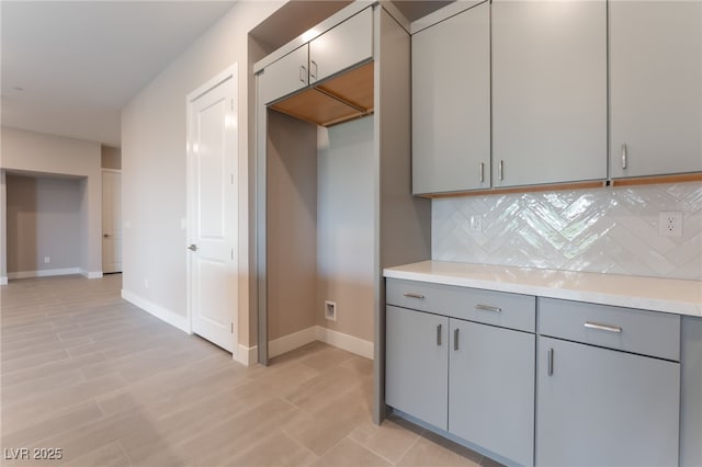 128 Los Cabos Dr Unit 301, Las Vegas, NV 89144 - kitchen featuring gray cabinets, tasteful backsplash, light countertops, and baseboards