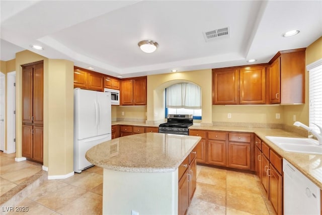 6558 Musette Ave, Las Vegas, NV 89139 - kitchen with appliances with stainless steel finishes, a sink, a raised ceiling, recessed lighting, and light stone countertops