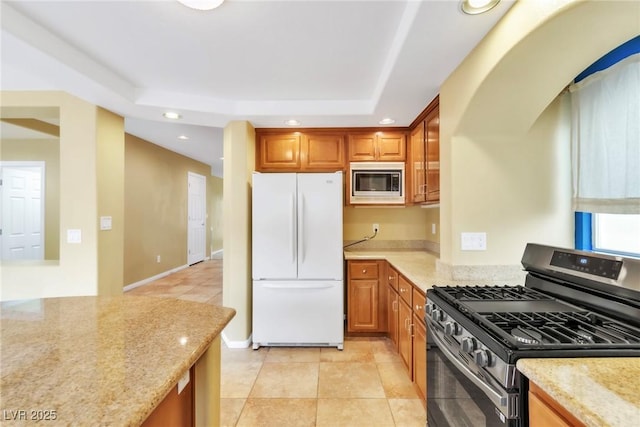 6558 Musette Ave, Las Vegas, NV 89139 - kitchen with appliances with stainless steel finishes, recessed lighting, a raised ceiling, light stone countertops, and light tile patterned flooring